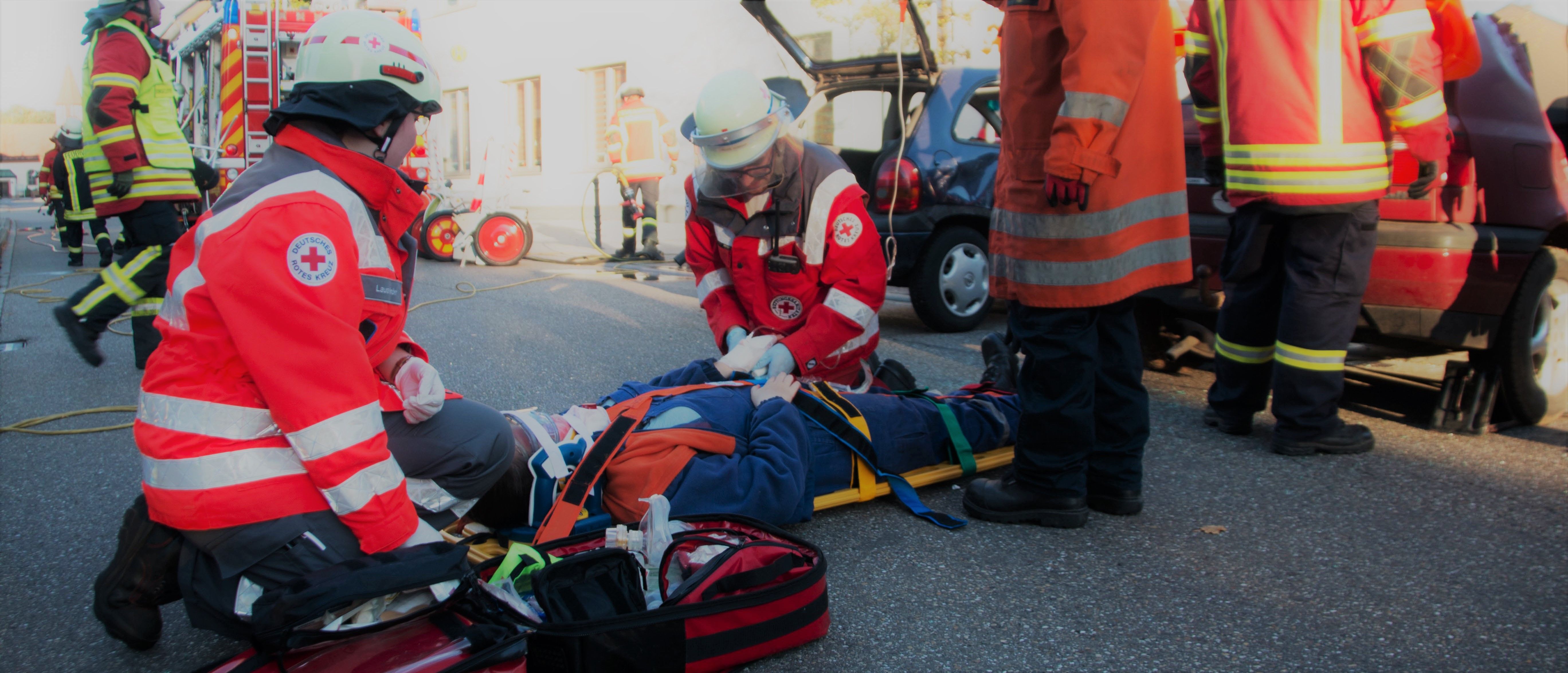 Foto: Zwei Helfer bei einer Übung am Spineboard beim Versorgen eines Verletzten
